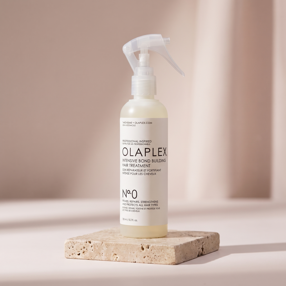 Olaplex No. 0 Bond Building Treatment styled on travertine pedestal, blush studio