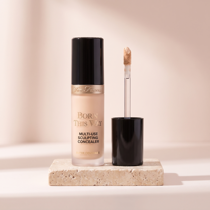 Too Faced Born This Way Concealer styled on travertine pedestal, blush studio