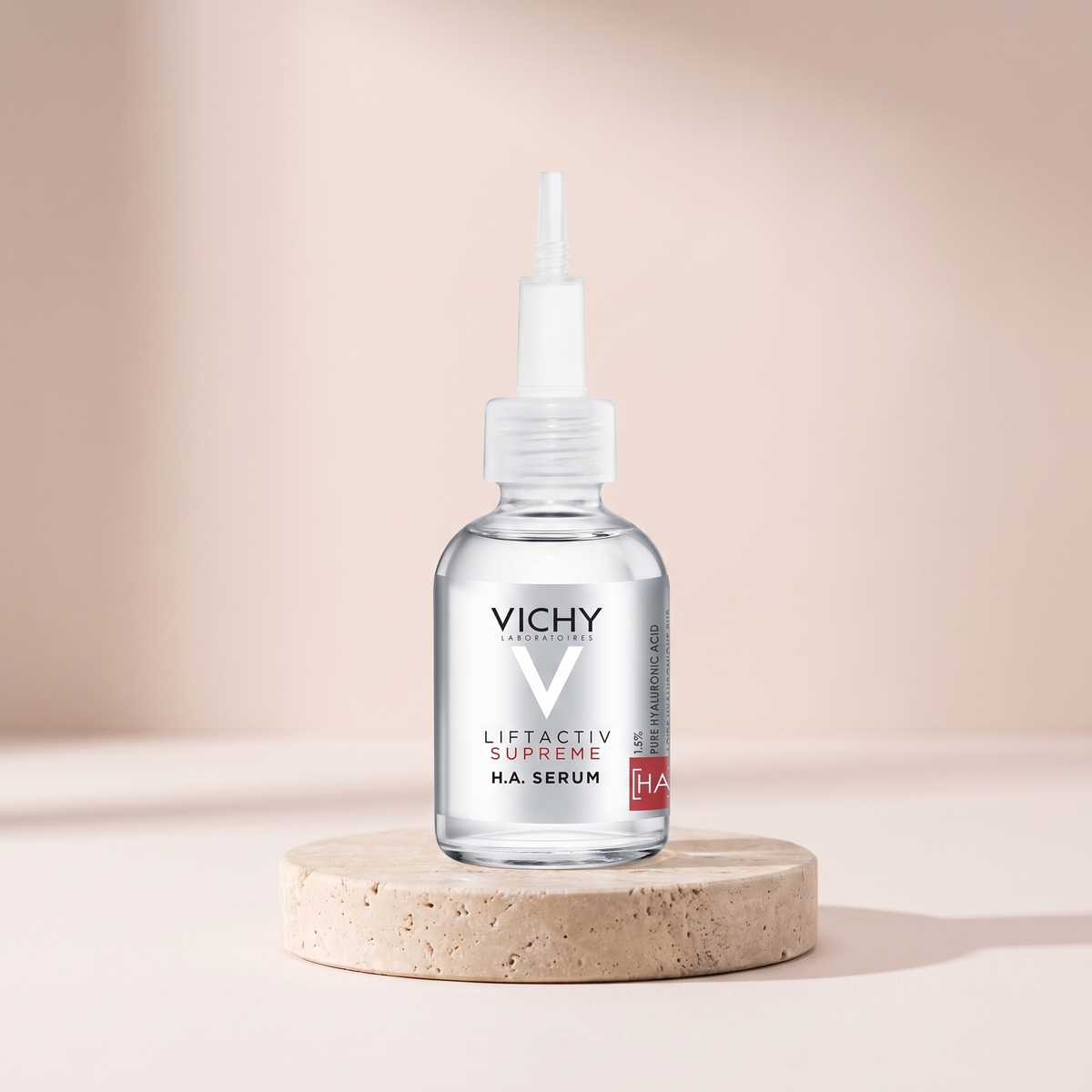Vichy LiftActiv Supreme HA Filler Serum styled on travertine pedestal, blush studio