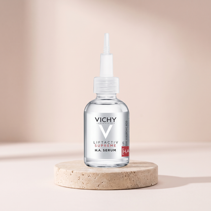 Vichy LiftActiv Supreme HA Filler Serum styled on travertine pedestal, blush studio
