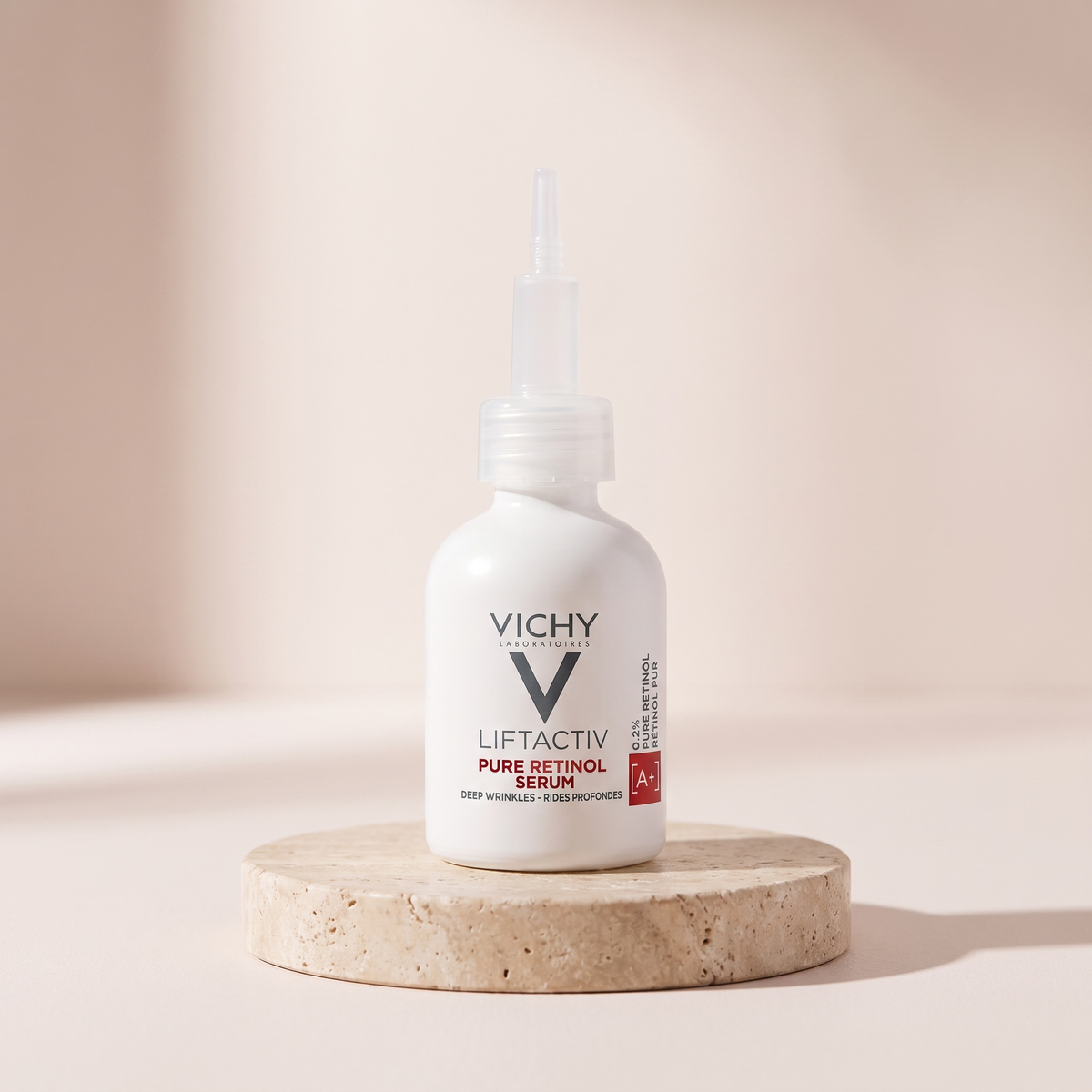 Vichy LiftActiv Retinol Specialist Serum styled on travertine pedestal, blush studio