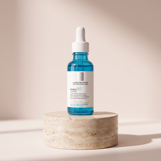 La Roche-Posay Hyalu B5 Plumping Serum styled on travertine pedestal, blush studio