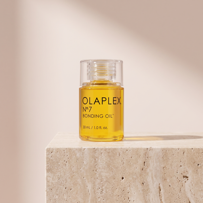 Olaplex No.7 Bonding Oil 30mL styled on travertine pedestal, blush studio