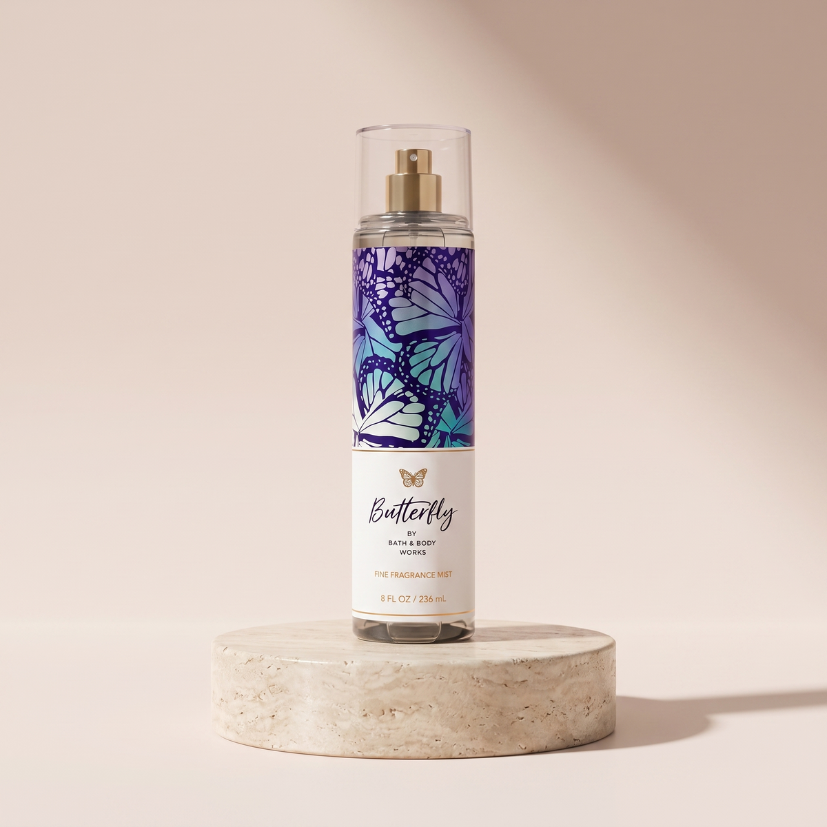 Bath and Body Works Butterfly Fine Fragrance Mist 236 ml styled on travertine pedestal, blush studio