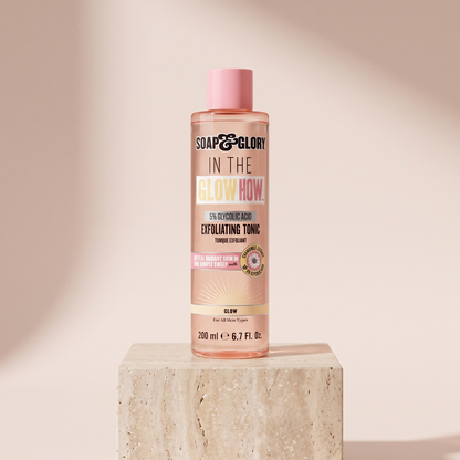 Soap and Glory In The Glow Glycolic Acid Exfoliating Toner styled on travertine pedestal, blush studio