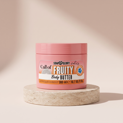Soap and Glory Call of Fruity Body Butter styled on travertine pedestal, blush studio