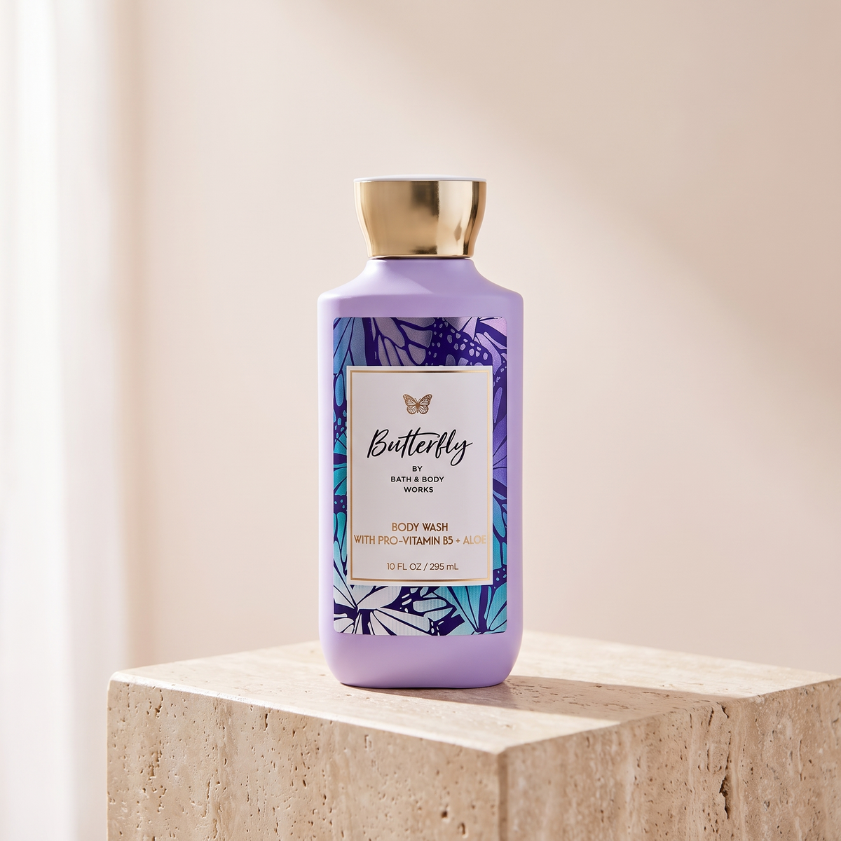 Bath and Body Works Butterfly Body Wash 295 ml styled on travertine pedestal, blush studio