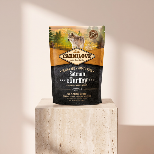 Carnilove Salmon and Turkey Dry Food for Large Breed Adult Dogs styled on travertine pedestal, blush studio