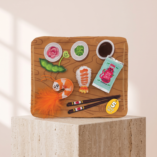 KONG Pull A Partz Sushi cat toy styled on travertine pedestal, blush studio