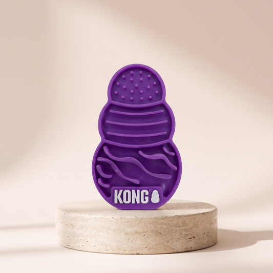 KONG Licks Kitty Treat Mat suction cup feeding pad styled on travertine pedestal, blush studio