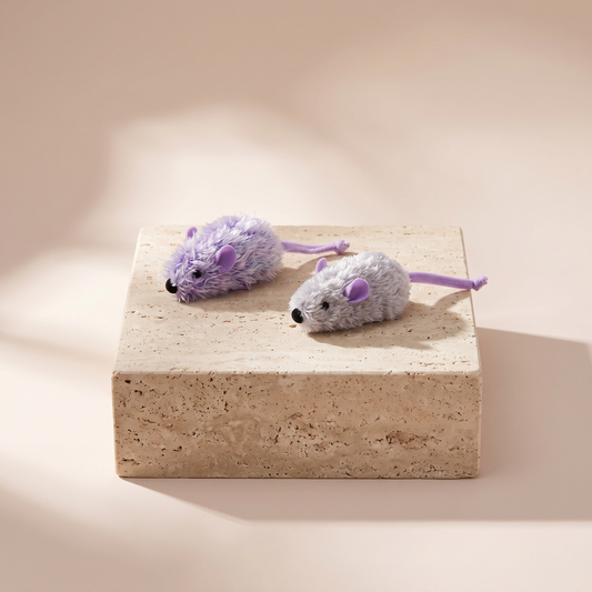 Purple and frosty grey plush mouse cat toy styled on travertine pedestal, blush studio